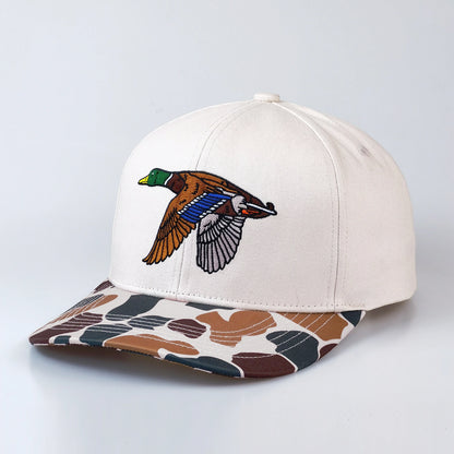 Off white cap with a colorful duck design on the front and camouflage-patterned brim on a light gray background